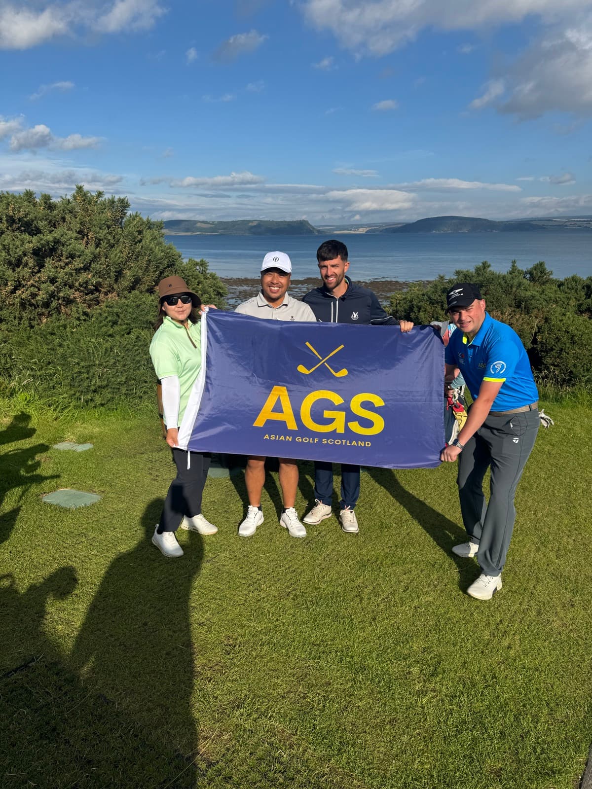 AGS guests holding the flag on the Scottish coast