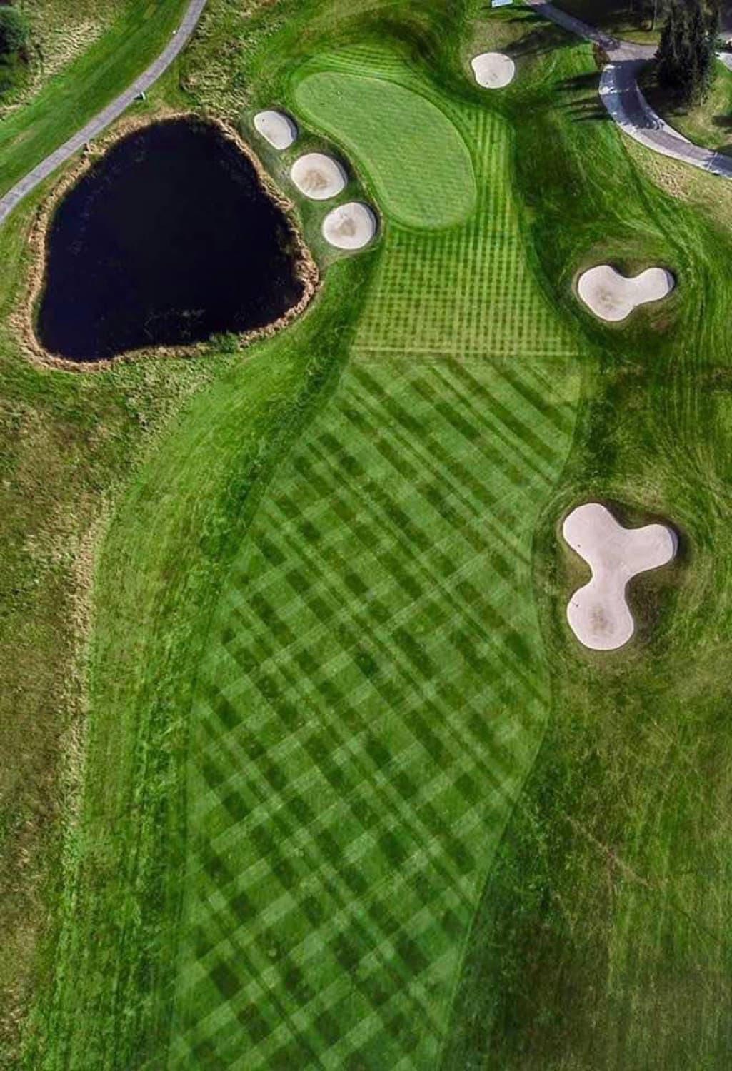 Aerial of a green guarded by bunkers and water